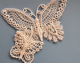 May include: White lace butterfly applique with intricate details. The butterfly has a delicate design with a smaller butterfly in the center.
