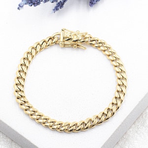 May include: A gold curb chain bracelet with a lobster clasp.