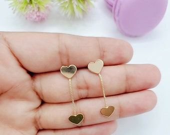 Può includere: Un paio di orecchini pendenti in oro con due ciondoli a forma di cuore su ogni orecchino.