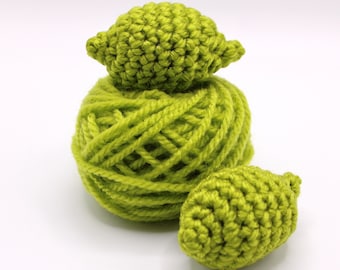 May include: A ball of green yarn with two crocheted lime-shaped ornaments on top.