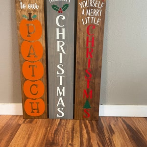 Pode incluir: Tr&ecirc;s placas de madeira com sauda&ccedil;&otilde;es de f&eacute;rias pintadas. A primeira placa diz "Bem-vindo ao nosso Patch" com ab&oacute;boras laranja. A segunda placa diz "Feliz Natal" em letras brancas sobre um fundo cinza. A terceira placa diz "Tenha um Feliz Natal Pequeno" em letras vermelhas sobre um fundo marrom.