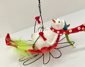 Happy Whimsical Snowboy Swinging on a Flower Christmas Ornament