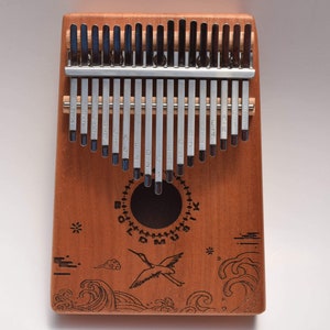 Front face of the kalimba thumb piano 17 key bird and ocean wave design.