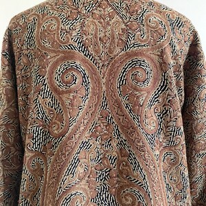 May include: A brown and black paisley patterned jacket with a collar and long sleeves.