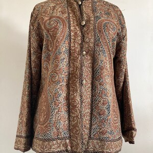 May include: A brown embroidered jacket with a paisley pattern and button closure.