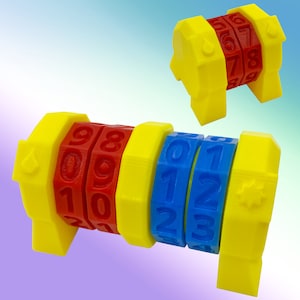 May include: A yellow, red, and blue combination lock with three rotating dials. Each dial has numbers 0-9 printed on it. The lock is made of plastic and has a small, round, yellow knob on the side.