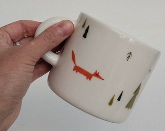 Taza de café con diseño de zorro pintado a mano, pino del bosque y estilo rústico.