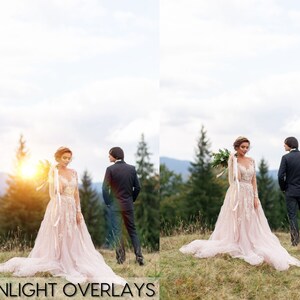 May include: A bride and groom pose for a wedding photo in a forest setting. The bride is wearing a long, flowing white dress with lace detailing. The groom is wearing a dark suit. The couple is standing in front of a lush green forest with a bright sun shining through the trees.