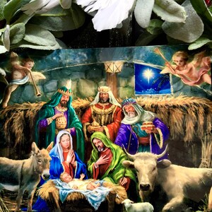 May include: A traditional Christmas nativity scene featuring a baby Jesus in a manger, surrounded by Mary, Joseph, a donkey, a cow, a sheep, and three wise men. The scene is set in a stable with straw on the floor and a star shining brightly in the night sky.