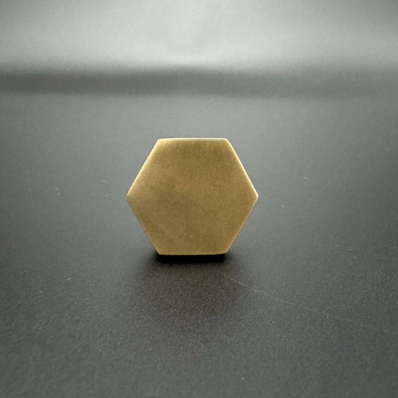 Pode incluir: Uma ma&ccedil;aneta hexagonal de lat&atilde;o com acabamento escovado.