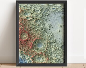 May include: A framed print of a close-up of the moon's surface, showing craters and other geological features in shades of green, blue, and red.