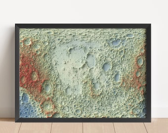 May include: A framed print of a colorful, textured image of the moon's surface. The image shows craters and other geological features in shades of blue, green, and red.