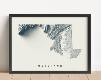 May include: A black framed print of a topographic map of Maryland. The map is in shades of grey and white and shows the state's physical features. The word "MARYLAND" is printed in black at the bottom of the print.