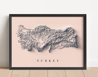 May include: A black framed print of a 3D topographic map of Turkey. The map is in shades of gray and white on a light pink background. The word "TURKEY" is printed in black at the bottom of the map.