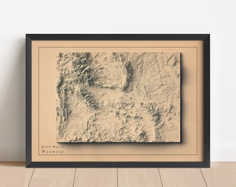 May include: A framed relief map of Wyoming with a beige background and black frame. The map shows the state's topography with raised areas representing mountains and valleys.