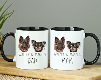 May include: Two white ceramic mugs with black handles and black rims. The mugs feature images of a German Shepherd and a Chihuahua. The text on the mugs reads "Walter & Mabel's Dad" and "Walter & Mabel's Mom".