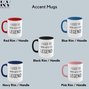Op de afbeelding: Set van vijf witte keramische mokken met zwarte tekst die "Ik heb met deze legende gewerkt" luidt. Elke mok heeft een rand en handvat in een andere kleur: rood, blauw, zwart, marineblauw en roze.