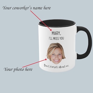 Op de afbeelding: Een witte keramische mok met een zwarte handgreep en rand. De mok heeft een foto van een vrouw met blond haar en de tekst "MARY, I'LL MISS YOU" en "Don't forget about me..." erop gedrukt.