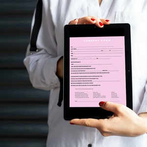Pu&ograve; includere: Una persona che tiene un tablet che mostra un modulo di consenso rosa con testo nero. Il modulo include sezioni per il nome, la data e la firma.