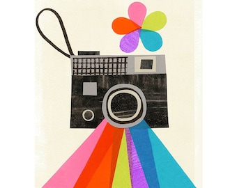 May include: A vintage camera with a rainbow emanating from the lens. A colorful flower sits on top of the camera. The artist's signature, "lyn Giunta", is in the bottom right corner.