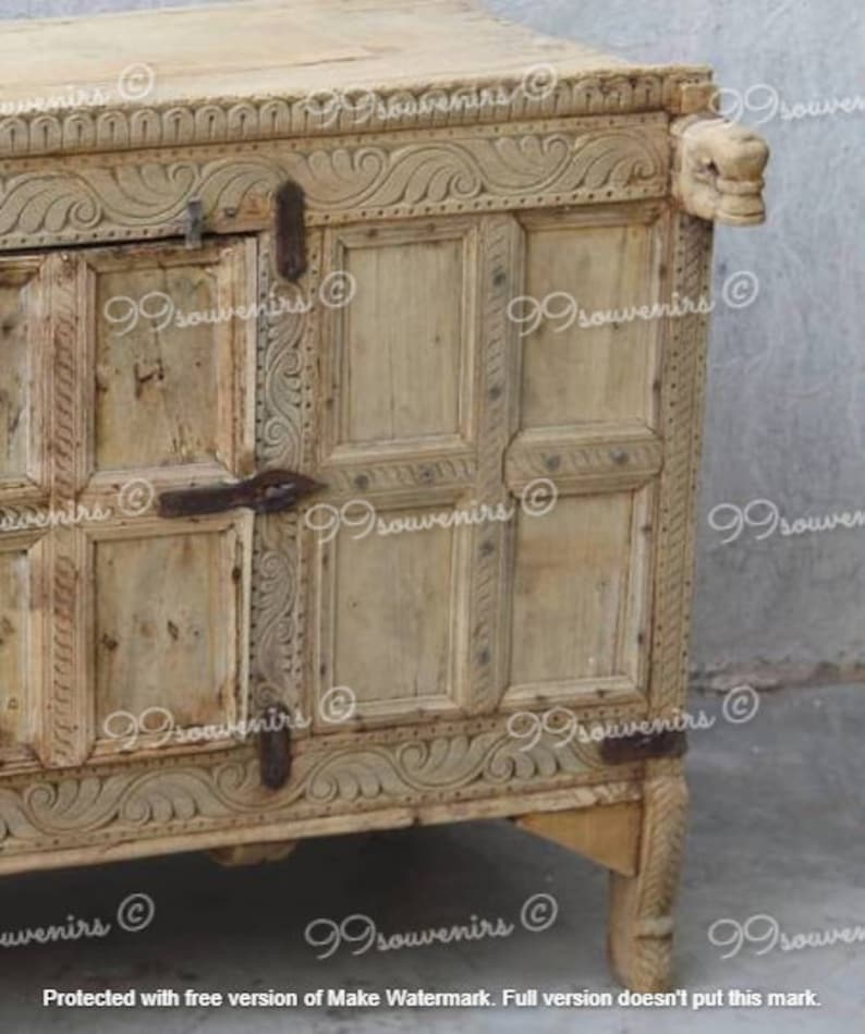 Puede incluir: Un armario de madera tallada con un acabado marr&oacute;n claro. El armario tiene un dise&ntilde;o decorativo con tallas intrincadas y una puerta con bisagras. El armario tiene cuatro patas y est&aacute; hecho de madera.