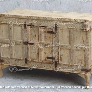 Puede incluir: Un cofre de madera blanco con intrincados tallados y una sola puerta. El cofre tiene una forma rectangular y se asienta sobre cuatro patas. El cofre est&aacute; hecho de madera clara y tiene un acabado desgastado.