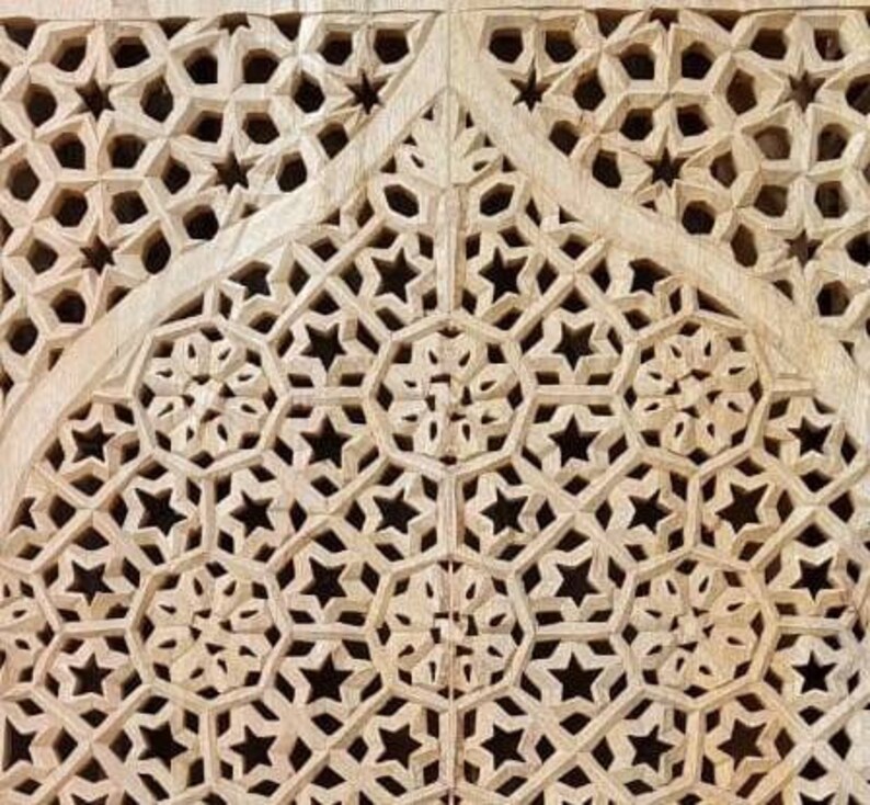 May include: Intricate wooden carving with a repeating pattern of stars and geometric shapes. The carving is light brown in color and has a smooth, polished finish.