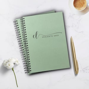 Könnte beinhalten: Ein grünes Spiralblock-Notizbuch mit dem Text "el PROJEKTE 2025" auf dem Einband.