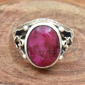 Peut inclure: Une bague en argent avec une pierre précieuse rose ovale sertie dans un décor en argent.