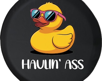May include: A yellow cartoon duck wearing pink sunglasses with blue lenses. The duck is on a black background with the words "HAULIN' ASS" in white text.