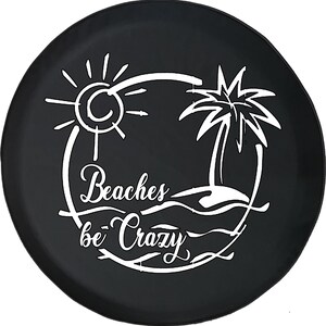 May include: Black spare tire cover with a white beach-themed design. The design includes a sun, palm tree, and the words "Beaches be Crazy" in a stylized font. The cover is round and likely made of durable material.