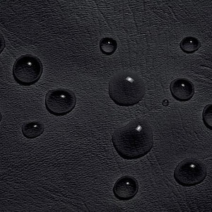 May include: Close-up of a black, textured surface with several large, clear water droplets. The droplets reflect light, creating bright highlights against the dark background. The surface appears to be leather or a similar material.