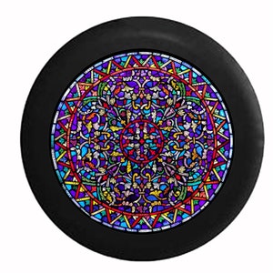 May include: A round, black object featuring a vibrant stained-glass design. The intricate pattern includes a central circle with a cross, surrounded by colorful floral and geometric shapes in shades of purple, blue, red, and yellow.