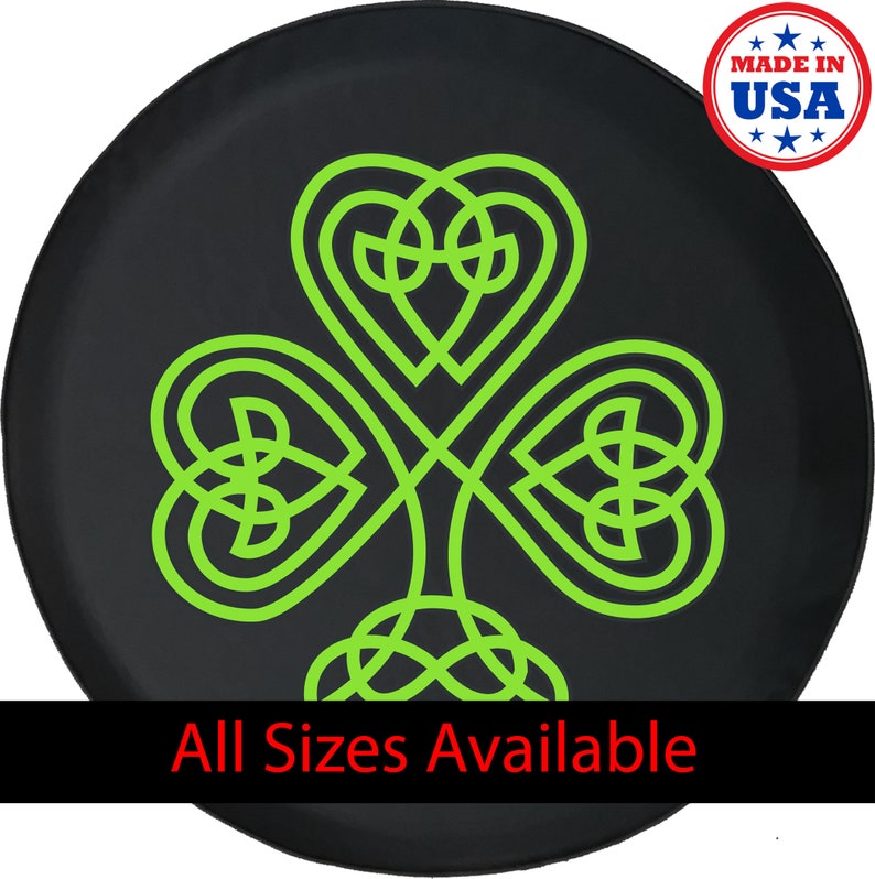 May include: Black tire cover featuring a neon green Celtic knot shamrock design. The shamrock is a three-leaf clover, a symbol of Ireland. The text "All Sizes Available" is at the bottom. A "Made in USA" sticker is in the upper right corner.