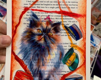 May include: A rectangular art print on a book page titled The Dungeon Anarchist's Cookbook, featuring a fluffy, dark-furred cat with yellow eyes and a pink crown, surrounded by six colorful, illustrated military-style caps and orange paint.