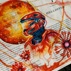 May include: A mixed media art print on book page paper featuring a red armored figure in a helmet, a large orange circular planet, and red floral motifs. The text HELLDIVER is printed in black above the figure, with white paint splatters.