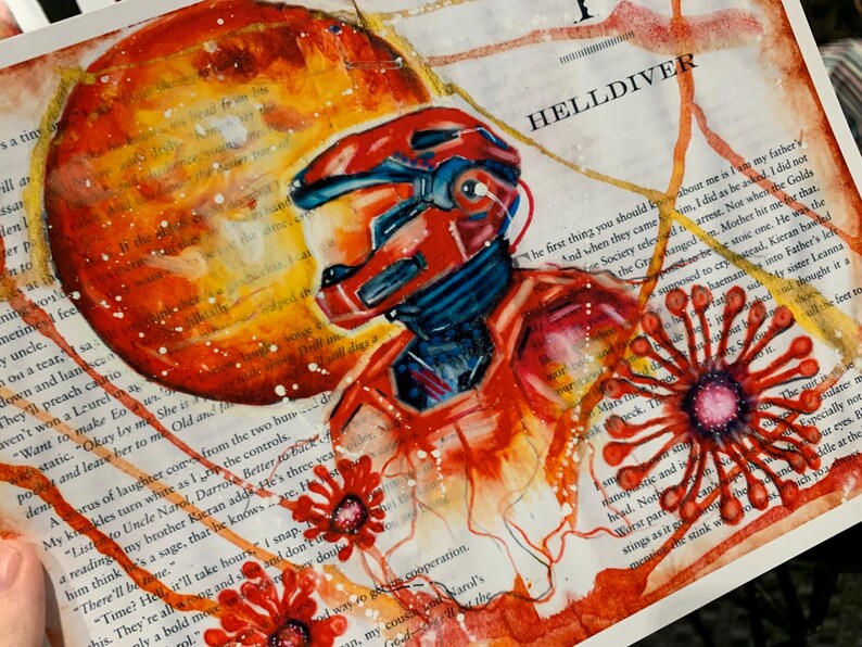 May include: A mixed media art print on book page paper featuring a red armored figure in a helmet, a large orange circular planet, and red floral motifs. The text HELLDIVER is printed in black above the figure, with white paint splatters.