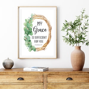 Può includere: Una stampa incorniciata con una ghirlanda ad acquerello di foglie e rami di eucalipto. La stampa presenta il testo "My Grace is Sufficient for You." con il riferimento biblico "2 Corinthians 12:9".