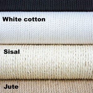 May include: Close-up of four different types of rope: black cotton, white cotton, sisal, and jute. The ropes are stacked on top of each other.