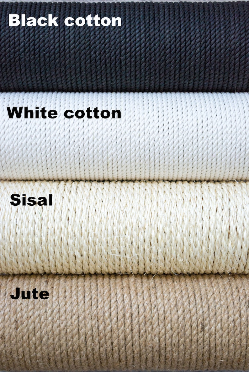 May include: Close-up of four different types of rope: black cotton, white cotton, sisal, and jute. The ropes are stacked on top of each other.