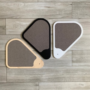 Puede incluir: Tres rascadores triangulares para gatos en diferentes colores: madera natural, negro y blanco. Cada poste tiene una superficie texturizada para rascar.