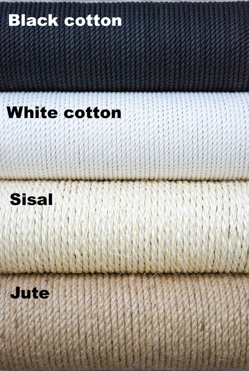 May include: Close-up of four different types of rope: black cotton, white cotton, sisal, and jute. The ropes are stacked on top of each other.