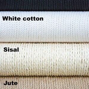 Pu&ograve; includere: Primo piano di quattro tipi diversi di corda: cotone nero, cotone bianco, sisal e juta. La corda &egrave; arrotolata e impilata l'una sull'altra. Il testo "Buda Pets own space" &egrave; visibile nell'angolo in basso a destra.