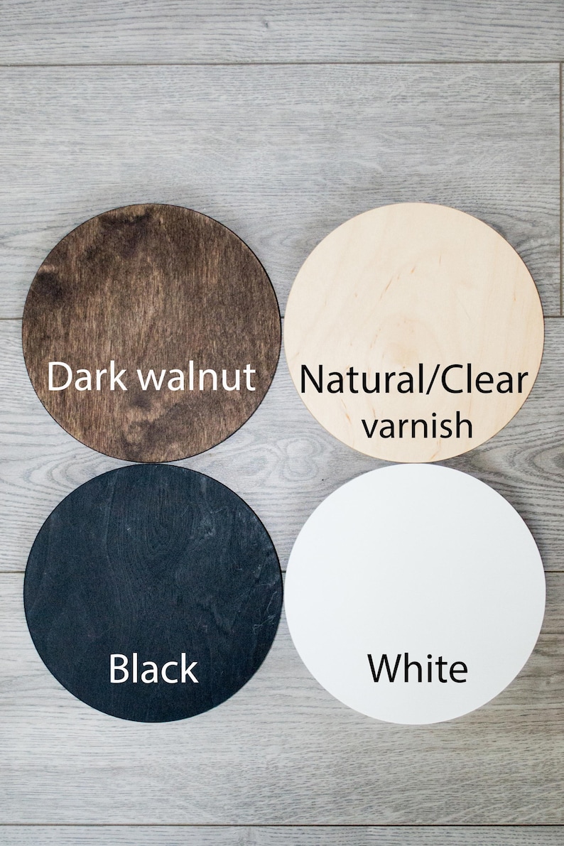 Pode incluir: Quatro discos redondos de madeira em diferentes cores: noz escura, verniz natural/transparente, preto e branco.