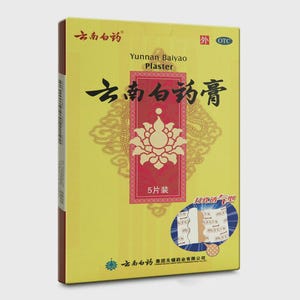 Puede incluir: Una caja amarilla de Yunnan Baiyao Plaster. La caja presenta caracteres chinos y un rectángulo rojo con un diseño floral blanco. La caja también incluye el texto "5片装" y "OTC".