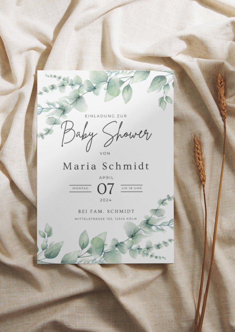 May include: A baby shower invitation with a white background, adorned with watercolor eucalyptus leaves. The invitation includes the text "Baby Shower" and details for Maria Schmidt's baby shower on April 7, 2024, in Cologne.