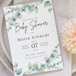 May include: A baby shower invitation with a watercolor eucalyptus design. The invitation includes the text "Baby Shower" and details for Maria Schmidt's baby shower on April 7, 2024, at 6 PM. The invitation is on a white background.