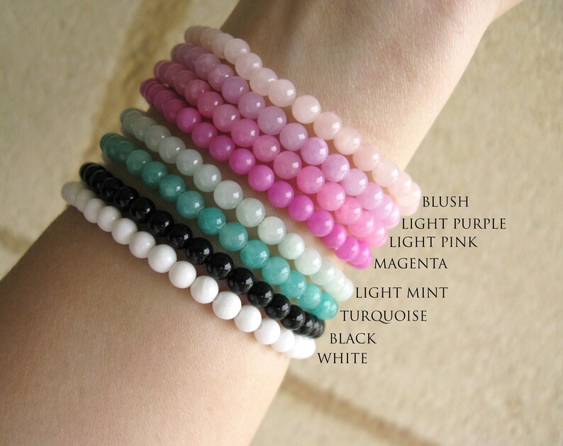 May include: A stack of colorful beaded bracelets in blush, light purple, light pink, magenta, light mint, turquoise, black, and white.
