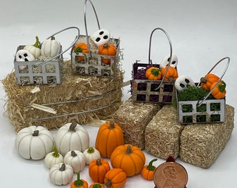 May include: A set of miniature Halloween and autumn decorations, including three wire baskets filled with white pumpkins and ghosts, and a collection of small white and orange pumpkins. The decorations are arranged on a bed of straw.