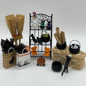 Peut inclure: Une scène miniature d'Halloween avec une étagère en métal noir, deux balais, deux sacs cadeaux, deux ours en peluche, un chaudron, un chat noir et divers objets de décoration d'Halloween.